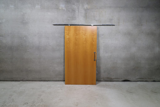 Skydedørsplade der måler 102,5 x 203,5 cm med skinne i 200 cm længde. Døren er brugt og stammer fra offentlig bygning.